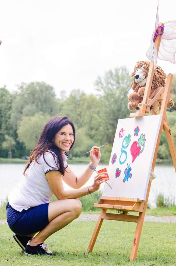 Tanja Grallert zeichnet am Flipchart das planbare Glücksmomente Logo